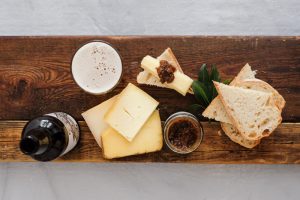 birds eye view of a cheese board with a beer