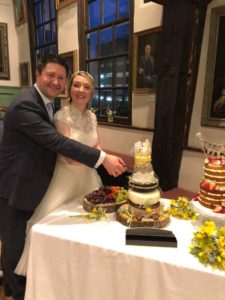a happy couple cut a cheese cake at their wedding