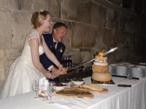 couple use sword to cut cheese cake tower at wedding