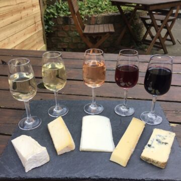 5 wines and 5 cheese pairings on a black slate