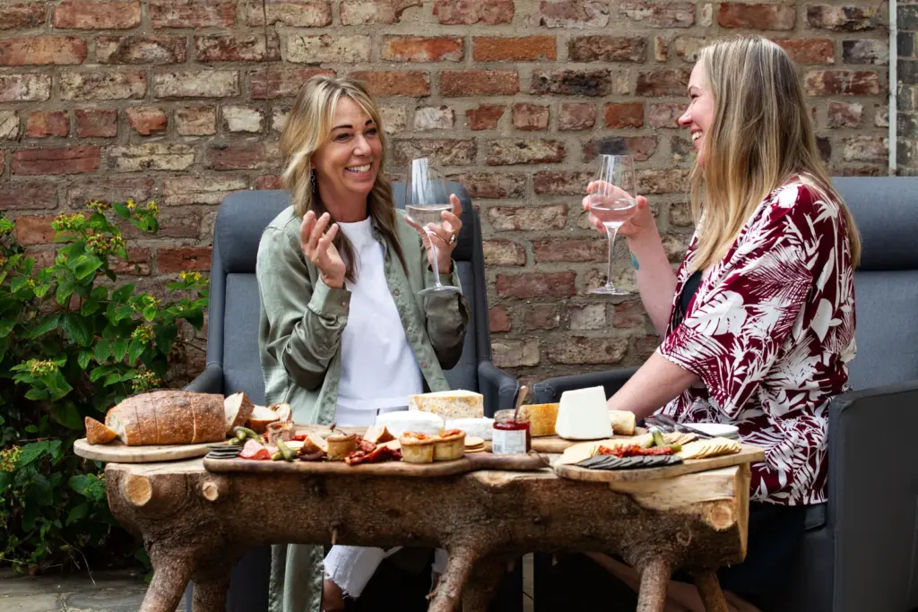 How to Make a Charcuterie Board: A Cheesemonger's Guide 5 Two friends with wine at a garden table laid with a grazing board