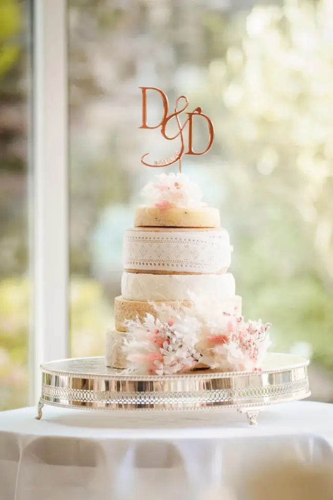 Cheese Wedding Cakes: How Much Cheese, Which Cheeses and How It Works 4 A cheese wedding cake with a monogram topper and pale flowers