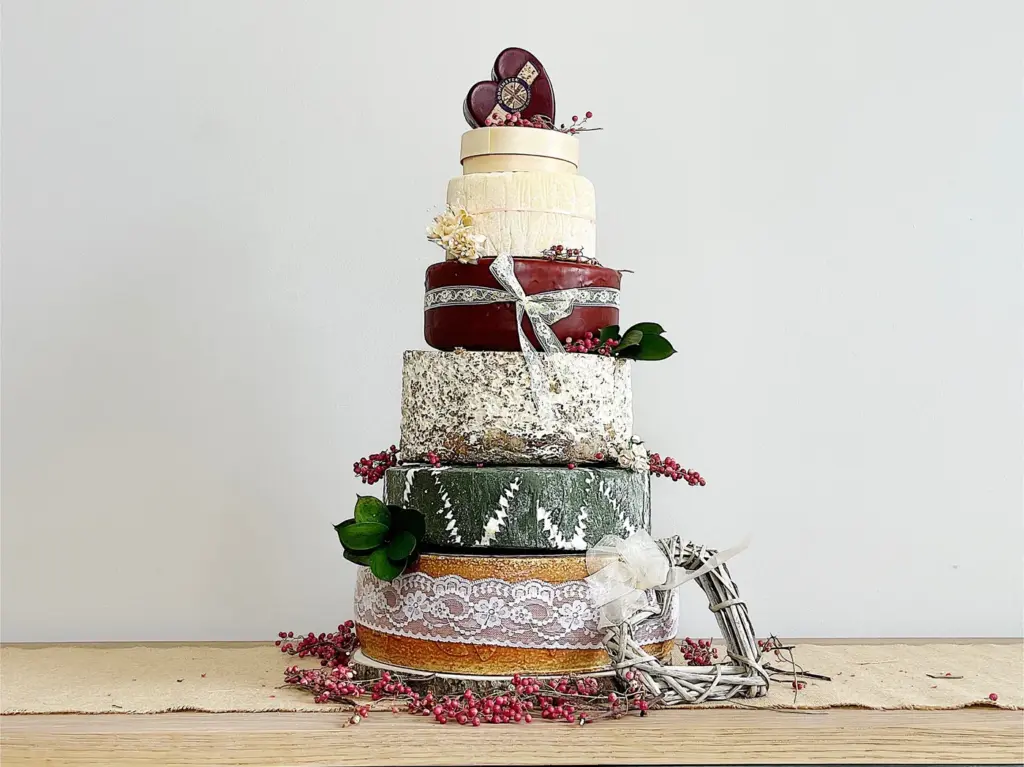 Cheese Wedding Cakes: How Much Cheese, Which Cheeses and How It Works 2 A cheese wedding cake dressed with ribbon, lace, greenery and a heart topper